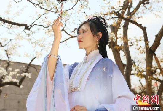 圖為蘭州青年身穿漢服在百年梨園賞景?！「哒?攝