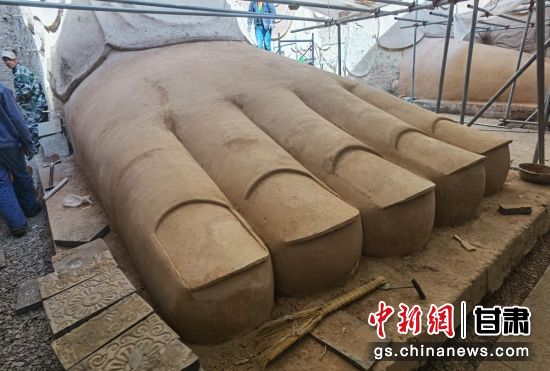 圖為中國“石窟鼻祖”天梯山石窟第13窟大佛足部與局部危巖體搶救性保護項目施工現(xiàn)場。陳曉斌 攝