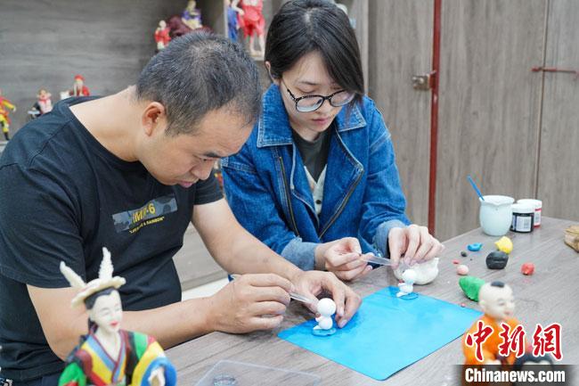 <a target='_blank'  data-cke-saved- >中新社</a>記者(右)現(xiàn)場(chǎng)體驗(yàn)面塑制作過(guò)程?！￡悹?zhēng)強(qiáng) 攝