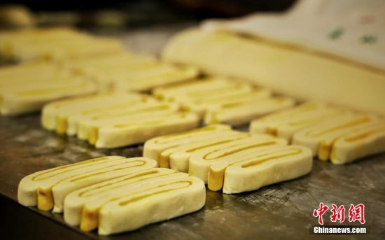 圖為面劑被涂上胡麻油，切成條狀用作月餅的花型制作。張文 攝