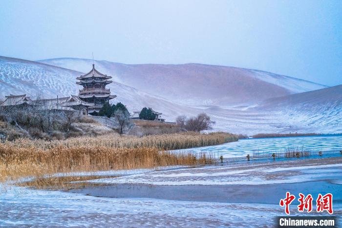 2021年11月28日，雪落鳴沙山月牙泉景區(qū)?！⊥醣筱y 攝