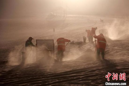 圖為敦煌市鳴沙山月牙泉景區(qū)“駱駝保姆”清理駱駝糞便?！垥粤?攝