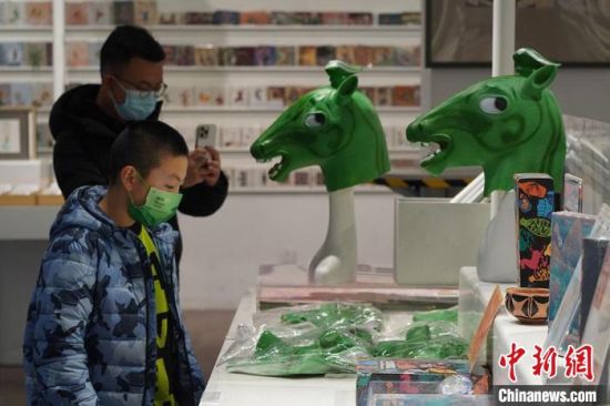 圖為“神馬來了”銅奔馬頭套吸引參觀者駐足?！【琶赖┰?攝