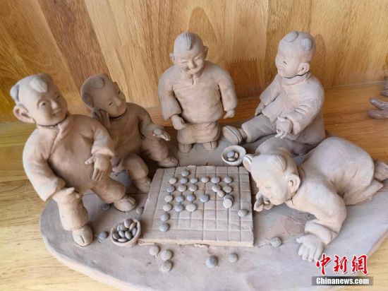 圖為泥塑作品展現(xiàn)下棋場(chǎng)景。 劉玉桃 攝