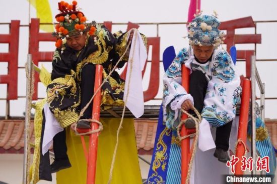 圖為“苦水高高蹺”表演者通過麻繩將腳固定在腳踏板，并在腿部纏繞六七圈?！【琶赖┰?攝