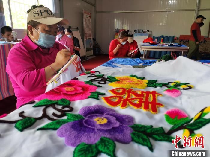 圖為婦女制作青繡?！?zhí)砀?攝