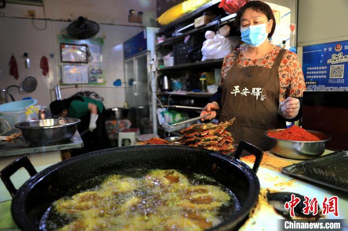 圖為平安驛·河湟民俗文化體驗地內的商戶炸干板魚?！⊙Φ?攝