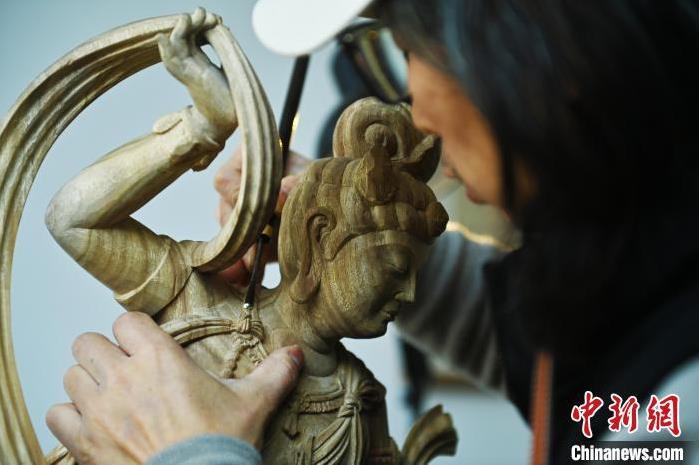 圖為季茂杰進(jìn)行敦煌元素的木雕創(chuàng)作。李亞龍 攝</p>
<p>