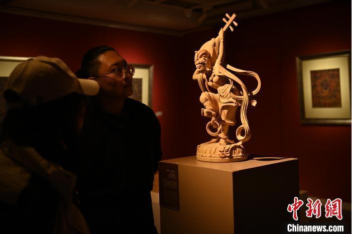 圖為季茂杰向參觀者介紹自己創(chuàng)作敦煌木雕的過(guò)程。李亞龍 攝</p>
<p>