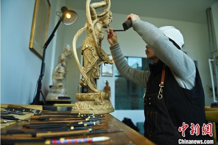 圖為季茂杰進(jìn)行敦煌元素的木雕創(chuàng)作。李亞龍 攝</p>
<p>