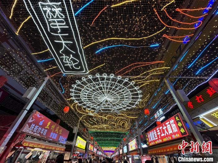 圖為明清街夜市燈光點(diǎn)亮具有武威文化元素的“摩天輪”彩燈?！〈魑牟?攝</p><p>