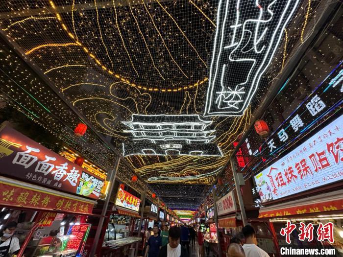 圖為明清街夜市燈光點(diǎn)亮具有武威文化元素的“涼州古城門”彩燈。　戴文昌 攝</p><p>