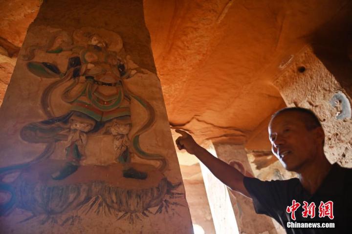 7月15日，甘肅省平?jīng)鍪袥艽h百里石窟長(zhǎng)廊羅漢洞石窟內(nèi)，該窟文保員郭建平介紹窟內(nèi)石刻彩繪壁畫(huà)。郭建平家中三代人曾自發(fā)保護(hù)羅漢洞石窟。羅漢洞石窟遺存40余個(gè)窟龕，以北魏至清代風(fēng)格為主。中新社記者 李亞龍 攝</p>
<p>